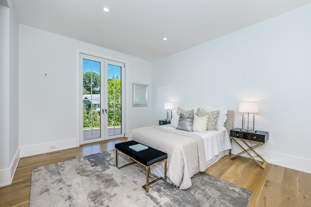 bedroom featuring wood-type flooring and access to outside