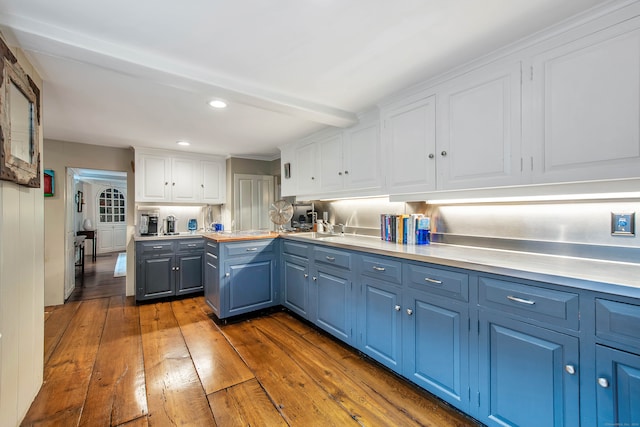 kitchen with blue cabinetry, white cabinetry, and dark hardwood / wood-style floors