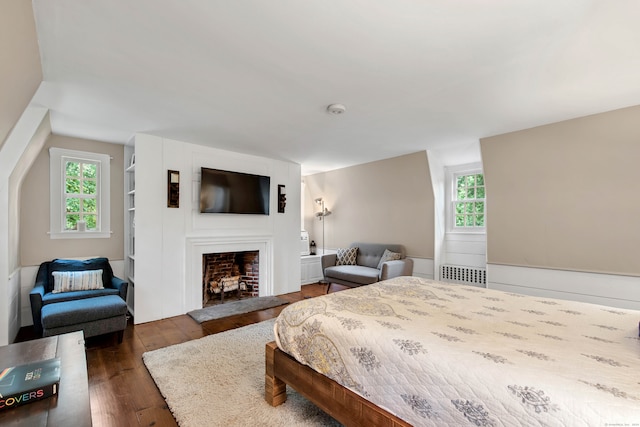 bedroom with dark wood-type flooring, multiple windows, and radiator