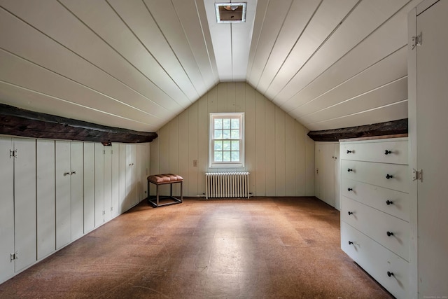 additional living space featuring lofted ceiling, radiator heating unit, and wooden walls