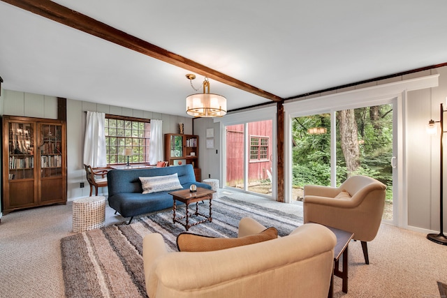 carpeted living room featuring beamed ceiling and an inviting chandelier