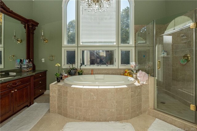 bathroom featuring independent shower and bath, vanity, and tile floors