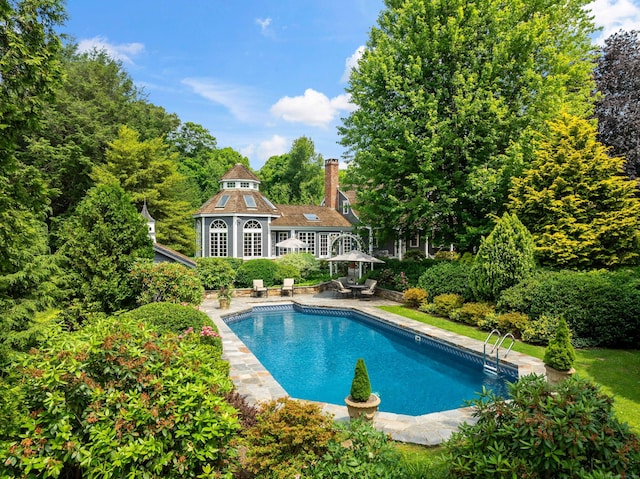 view of swimming pool with an outbuilding and a patio area