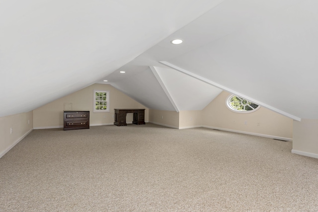 additional living space featuring vaulted ceiling and carpet flooring