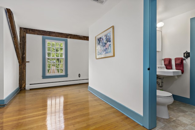 interior space with a baseboard radiator and light hardwood / wood-style flooring