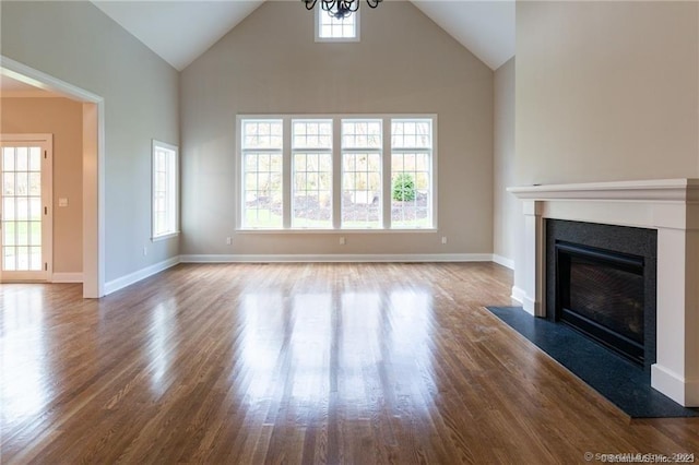 22 Somerset Dr, Middlebury, CT 06762 - unfurnished living room featuring high vaulted ceiling, healthy amount of natural light, wood finished floors, a fireplace with flush hearth, and a chandelier