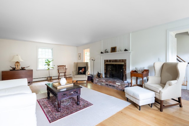 living room featuring hardwood / wood-style flooring, a fireplace, and baseboard heating