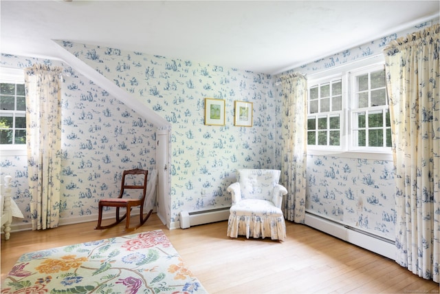 living area with light wood-type flooring and baseboard heating