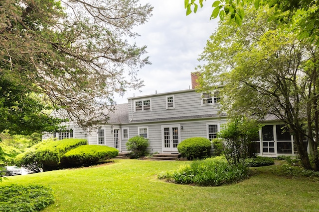 rear view of house featuring french doors and a yard