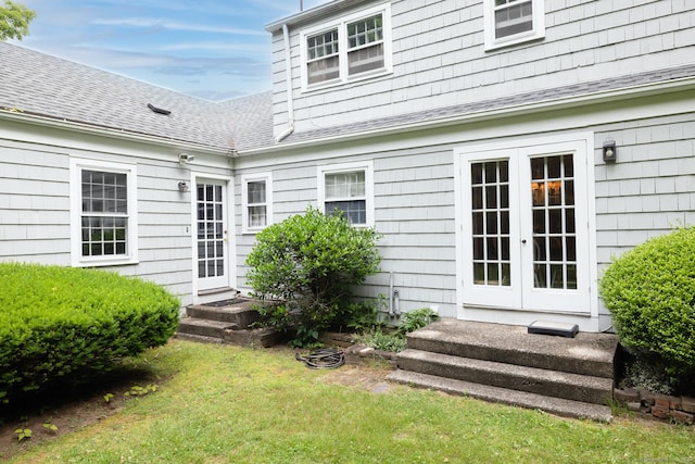 back of property featuring a lawn and french doors