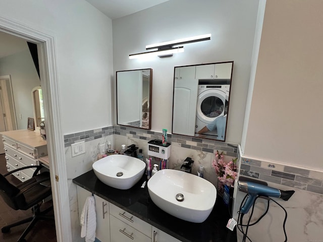 bathroom with vanity, washer / dryer, and decorative backsplash