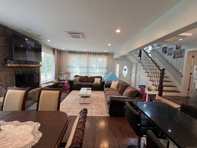 living room with a fireplace and dark wood-type flooring