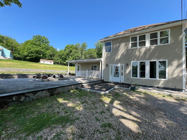 back of property featuring a yard and a porch