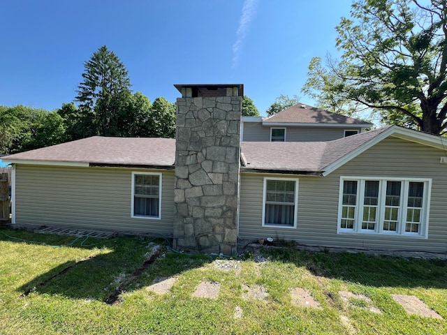 rear view of property featuring a lawn