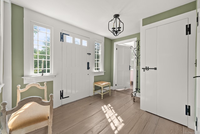 foyer entrance featuring a notable chandelier and light wood-type flooring