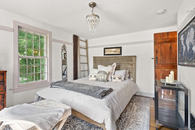 bedroom with a notable chandelier and hardwood / wood-style flooring