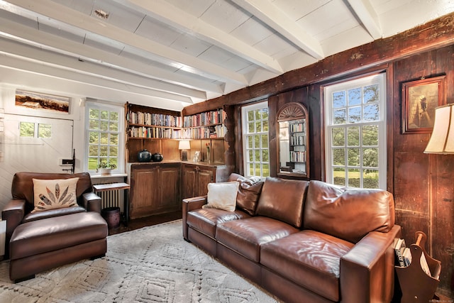 living room featuring radiator heating unit, beam ceiling, and wooden walls