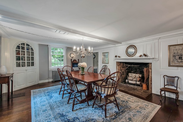 dining room with radiator heating unit, ornamental molding, a chandelier, a fireplace, and dark hardwood / wood-style flooring