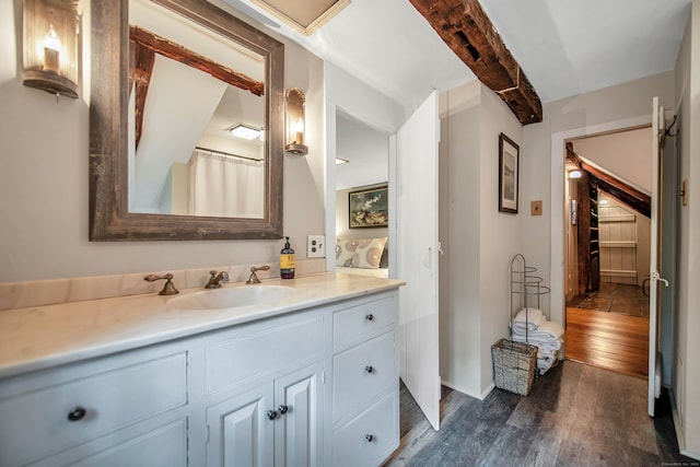 bathroom featuring beamed ceiling, vanity, and wood-type flooring