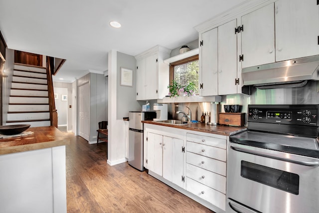 kitchen featuring light hardwood / wood-style flooring, stainless steel electric range, sink, and white cabinets