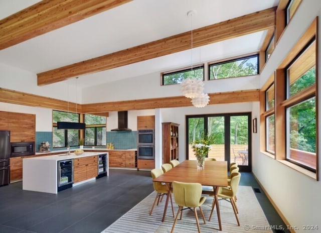 dining area with a chandelier, wine cooler, and plenty of natural light