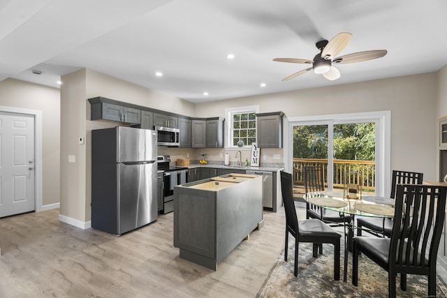 203 Winding Hollow Rd, Groton, CT 06340 - kitchen featuring appliances with stainless steel finishes, a center island, a ceiling fan, and light wood-type flooring