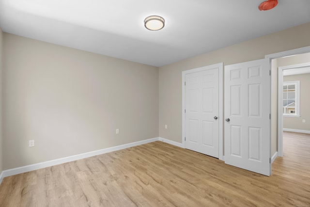 203 Winding Hollow Rd, Groton, CT 06340 - unfurnished bedroom featuring baseboards, light wood-style floors, and a closet