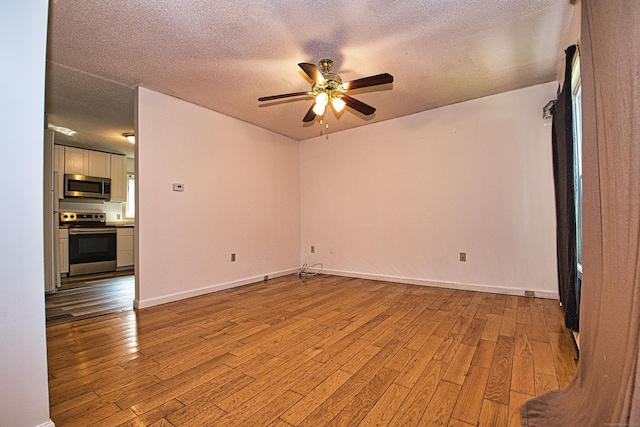 unfurnished room featuring ceiling fan, a textured ceiling, and light wood-type flooring