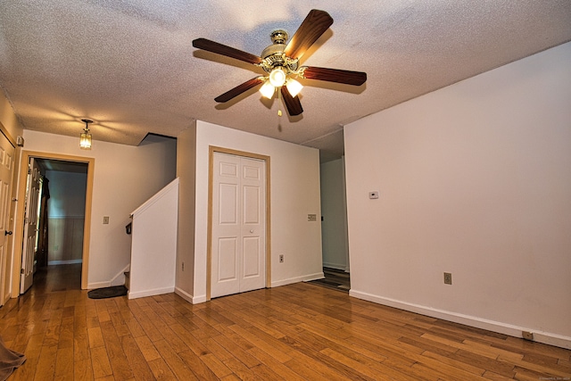 unfurnished room featuring a textured ceiling, hardwood / wood-style flooring, and ceiling fan