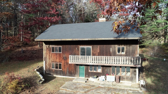 view of front of property featuring a balcony and a patio