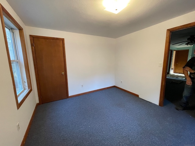 carpeted spare room with ceiling fan