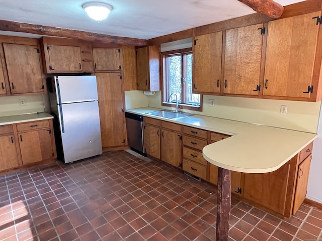 kitchen featuring dark tile patterned flooring, refrigerator, sink, and stainless steel dishwasher