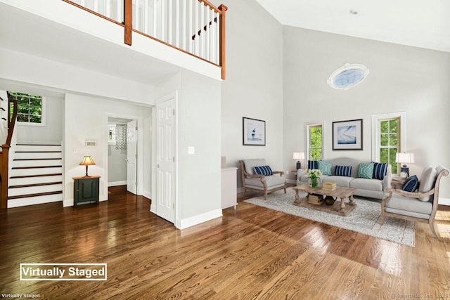 living room featuring dark wood-type flooring and a towering ceiling