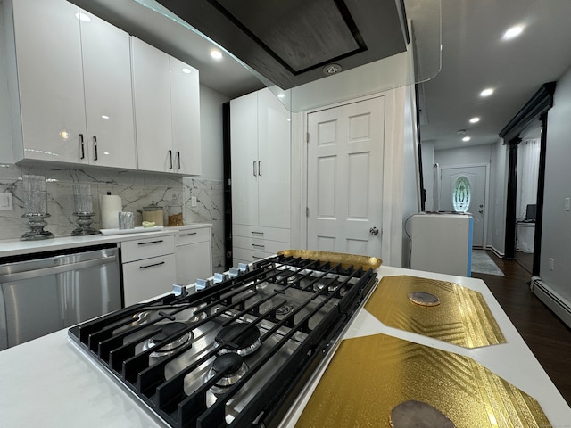 kitchen with white cabinetry, dark wood-type flooring, stainless steel dishwasher, gas stovetop, and backsplash