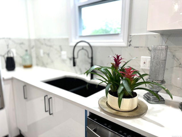 kitchen with sink, dishwasher, backsplash, and white cabinetry