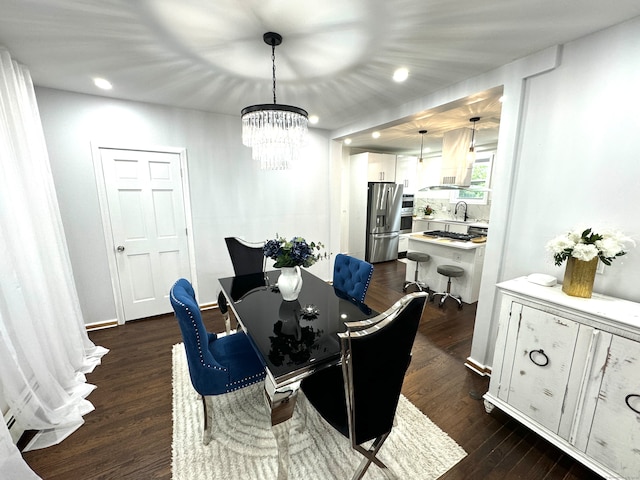 dining area featuring an inviting chandelier, sink, and dark hardwood / wood-style floors