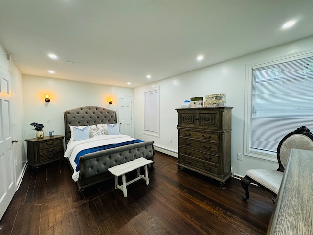 bedroom with a baseboard heating unit and dark wood-type flooring