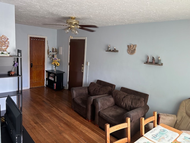 living room with a textured ceiling, dark hardwood / wood-style floors, and ceiling fan