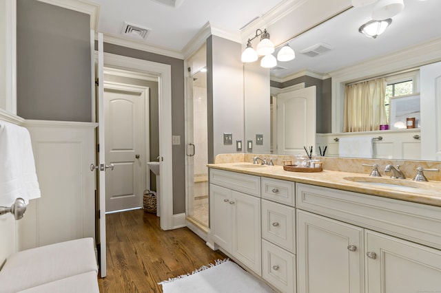 bathroom featuring vanity, crown molding, hardwood / wood-style flooring, and walk in shower