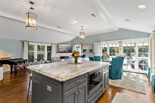 kitchen featuring built in microwave, a healthy amount of sunlight, a center island, and dark hardwood / wood-style flooring