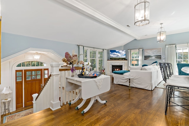 dining area featuring vaulted ceiling with beams, plenty of natural light, dark hardwood / wood-style floors, and a high end fireplace