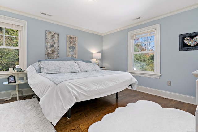 bedroom featuring multiple windows, dark wood-type flooring, and crown molding