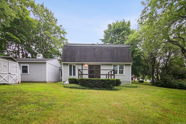 rear view of house featuring a storage shed and a lawn