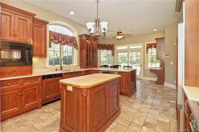 kitchen featuring plenty of natural light, sink, a center island, dishwasher, and black microwave