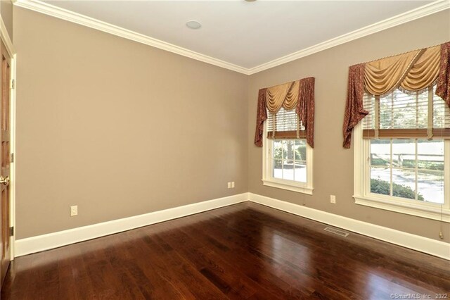 spare room featuring ornamental molding and dark hardwood / wood-style floors