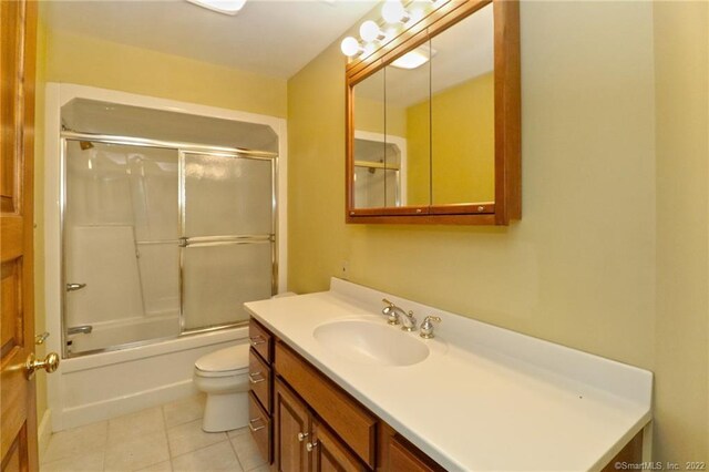 full bathroom with tile patterned floors, toilet, enclosed tub / shower combo, and vanity