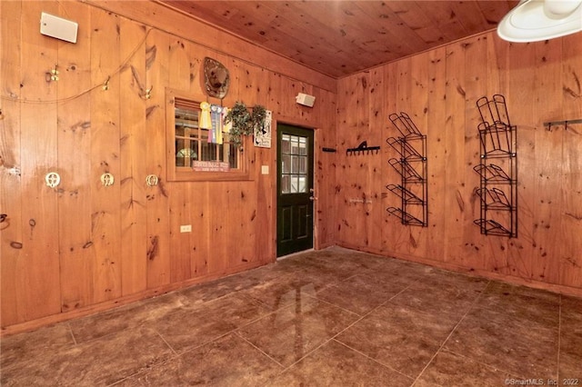 tiled empty room featuring wooden ceiling and wooden walls