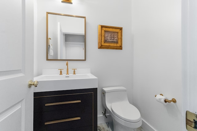 half bath with toilet, vanity, and baseboards