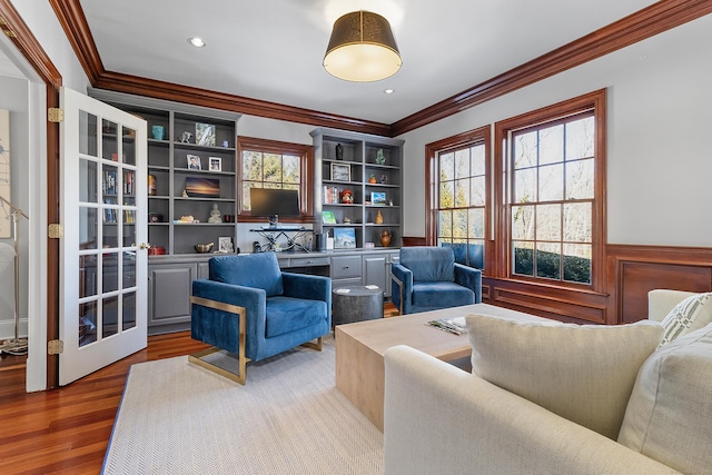 interior space featuring crown molding, wainscoting, and wood finished floors
