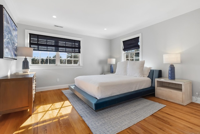 bedroom featuring baseboards, visible vents, and multiple windows